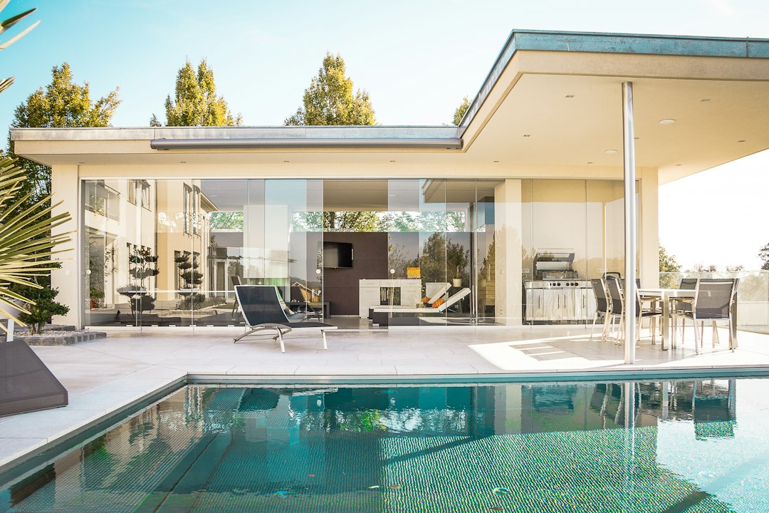 Villa with glass walls opening onto a swimming pool